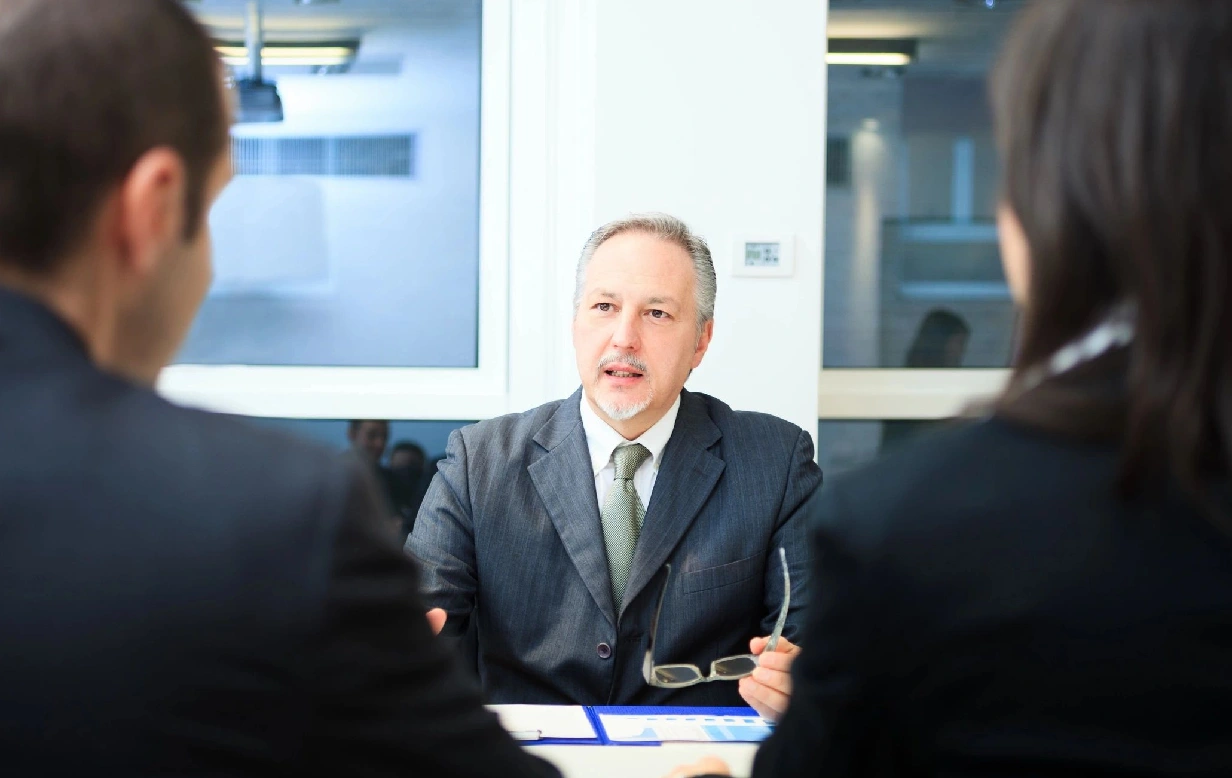 A man in suit and tie sitting at a table.